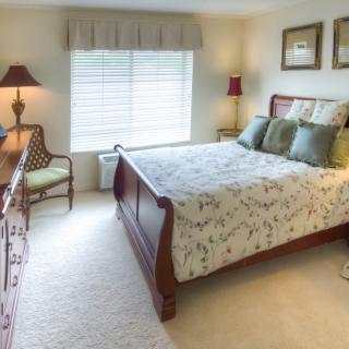 A cozy bedroom with classic wooden furniture and soft lighting.