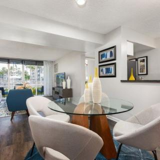 A modern living and dining area featuring a glass table, stylish chairs, and elegant decor.