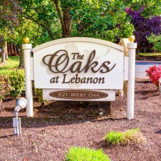 Entrance sign for The Oaks at Lebanon, surrounded by trees and landscaping.