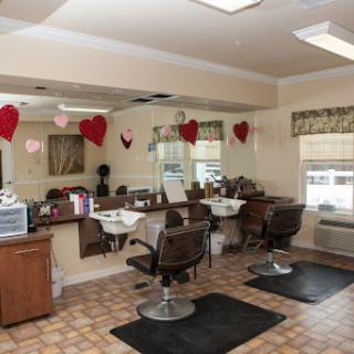 A cozy hair salon featuring styling stations with mirrors and comfortable chairs, decorated for a warm ambiance.