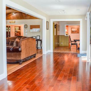 Spacious hallway with hardwood floors leading to a cozy living room.