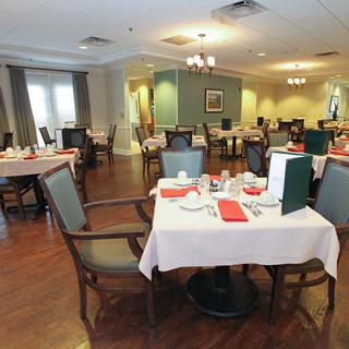 An elegantly set dining room with neatly arranged tables and chairs, ready for guests.