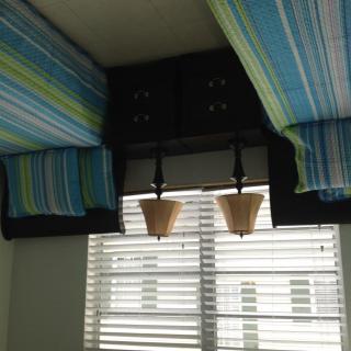 Interior view with striped fabric ceiling decor and window blinds.