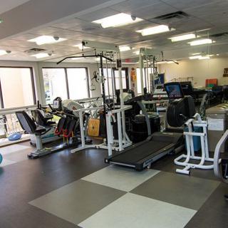 A spacious gym with various exercise equipment including treadmills and stationary bikes.