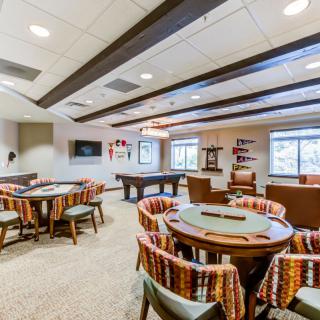 A spacious game room featuring a pool table, multiple tables with seating, and a cozy atmosphere for entertainment.
