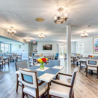 A modern and bright dining area with elegantly arranged tables and chairs.