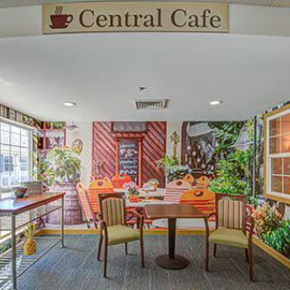 A cozy cafe interior with colorful wall art and seating arrangement.
