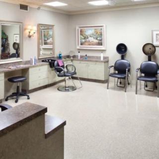 A well-organized hair salon with multiple chairs, mirrors, and drying units.