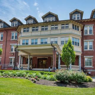 A historic brick building with classic architectural design and well-maintained landscaping.