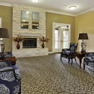 A cozy living room with elegant furniture and a central fireplace.