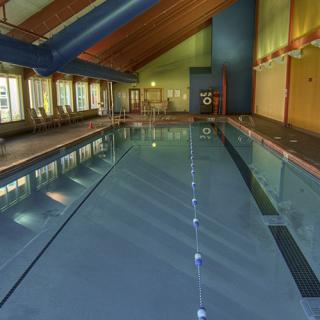 An indoor swimming pool with clear water and lane dividers inside a leisure center.