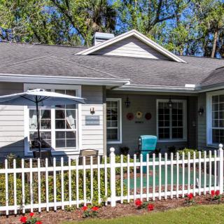 A charming suburban house with a white picket fence and a well-maintained garden.