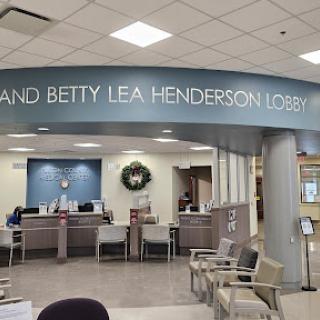 The entrance to the Grand and Betty Lea Henderson Lobby in a medical facility, featuring a spacious waiting area and reception desk.