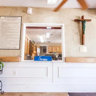 A reception area with a religious cross on the wall and a plaque next to it.