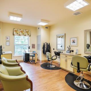 A well-lit hair salon interior with multiple chairs, mirrors, and equipment.