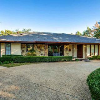 A single-story house with a spacious driveway and well-maintained landscaping.