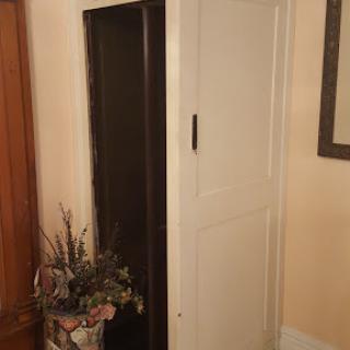 A stylish two-tone cabinet beside a decorative plant in a cozy room.