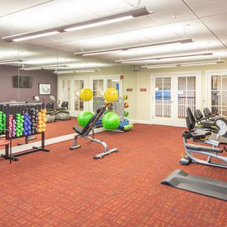 A well-equipped gym with various exercise machines and weights.