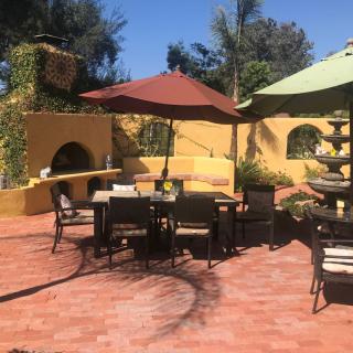A cozy patio with seating and umbrellas under a sunny sky.
