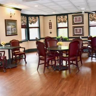 A cozy dining area with polished hardwood floors, classic furniture, and decorative elements.