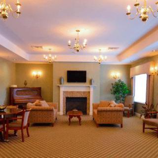 A cozy living room featuring a fireplace, comfortable seating, and a piano.