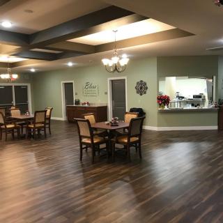 A spacious dining area with elegant lighting and hardwood flooring.