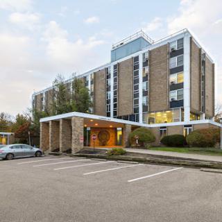A modern hotel building with a well-defined entrance and ample parking space.