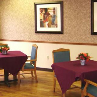 A cozy dining area with tables and chairs, adorned with artwork on the walls.