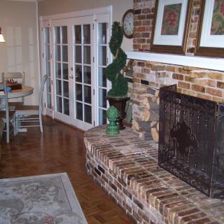 A cozy living room with a brick fireplace and hardwood flooring.