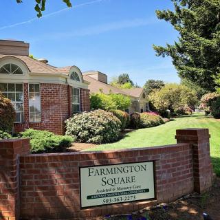 A well-maintained building surrounded by lush landscaping with a sign reading 'Farmington Square' in the foreground.