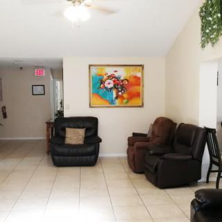 A cozy living room with leather sofas and a colorful abstract painting on the wall.