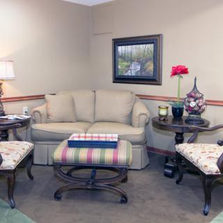 A cozy living room with a sofa, coffee table, and armchairs arranged around it.