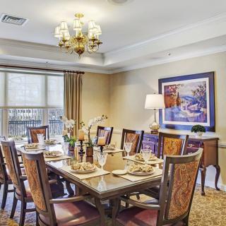 A traditional dining room with an elegantly set table and chandelier.