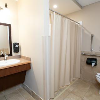 A clean and modern bathroom featuring a shower area, toilet, and vanity with sink.