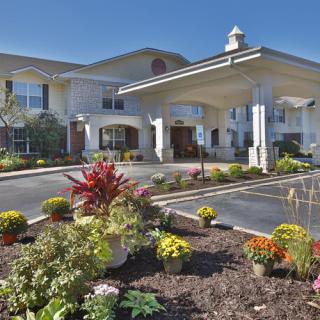 A well-landscaped entrance of a modern building with vibrant flowers and greenery.
