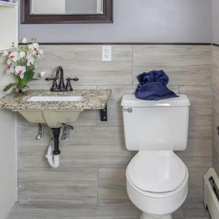A modern bathroom with a toilet, sink, and orchid decoration.