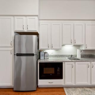 Modern kitchen with stainless steel refrigerator and built-in microwave.