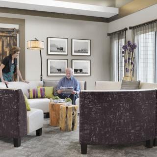 A modern living room with comfortable seating, artwork on the walls, and natural lighting.