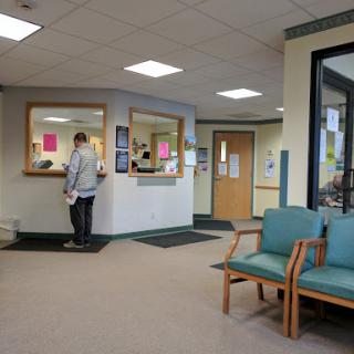 A view of a hospital waiting room with a patient at the reception.