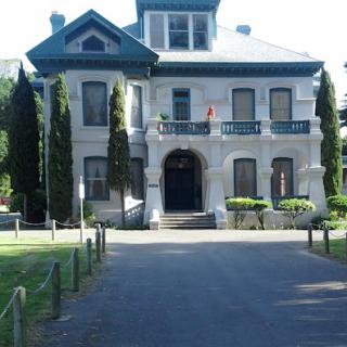 A beautiful historic mansion surrounded by greenery.