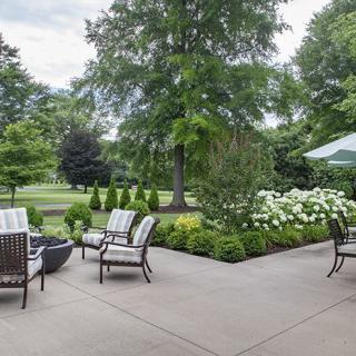 A beautifully landscaped backyard patio with outdoor furniture and lush greenery.