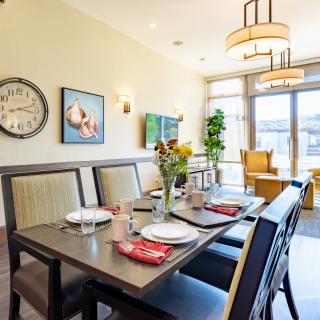 A well-lit dining room with a set table, featuring sunflowers and modern decor.