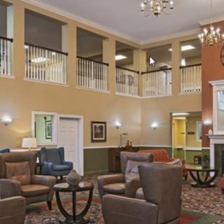 A cozy lobby with comfortable seating, warm lighting, and a chandelier.