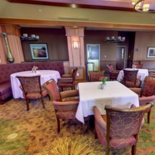 An elegantly decorated restaurant dining area with neatly arranged tables and chairs.