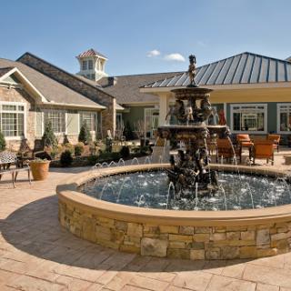 A beautifully designed outdoor space featuring a central fountain and comfortable seating areas.