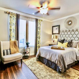 A stylish and cozy bedroom featuring modern decor elements and warm tones.