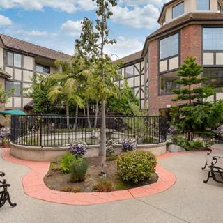 A view of a landscaped courtyard surrounded by a multi-story building.