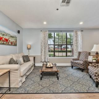 A cozy living room with a comfortable sofa, patterned armchairs, and a stylish coffee table on a decorative rug.