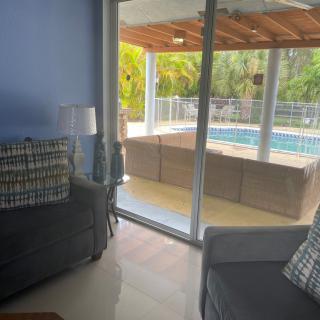 A cozy living room with a view of the pool through sliding glass doors.