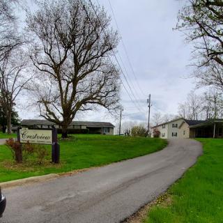 A scenic view of a winding road leading to a house in a rural setting.